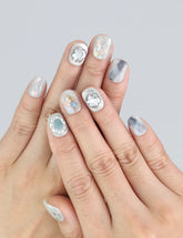 Wearing Naillover Opal Whisper press on nails—short smoky grey nails with gold shimmer accents.